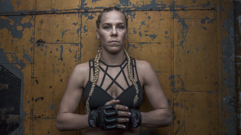 Katyn Chookagian, UFC fighter, poses for this portrait with braids and MMA gloves